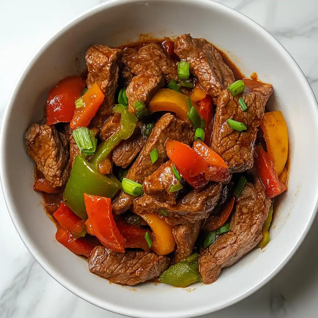 Low FODMAP Crockpot Steak & Peppers: Easy, Flavorful, Gut-Friendly 5 Low FODMAP Slow Cooker Steak and Peppers served in a white bowl with colorful bell peppers and green onions