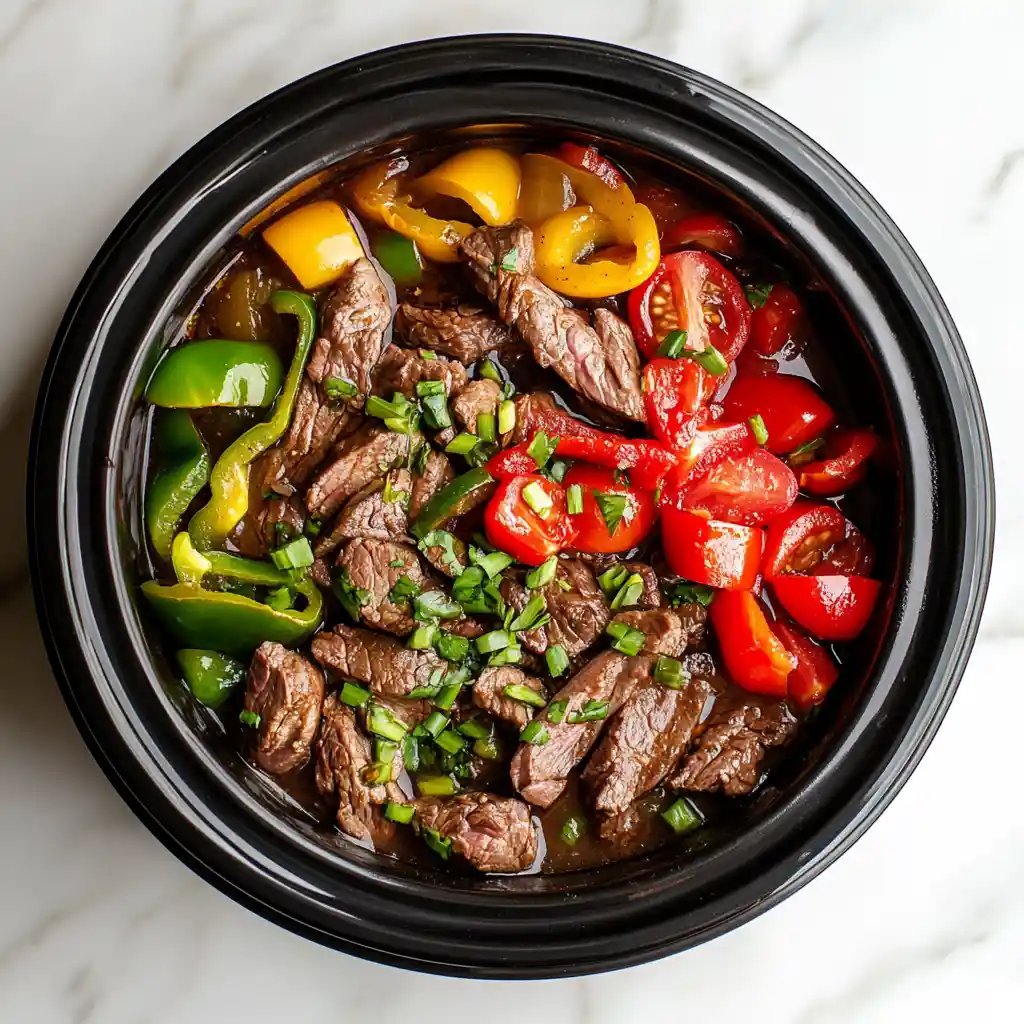 Low FODMAP Crockpot Steak & Peppers: Easy, Flavorful, Gut-Friendly 3 Low FODMAP Slow Cooker Steak and Peppers with fresh vegetables in round black slow cooker